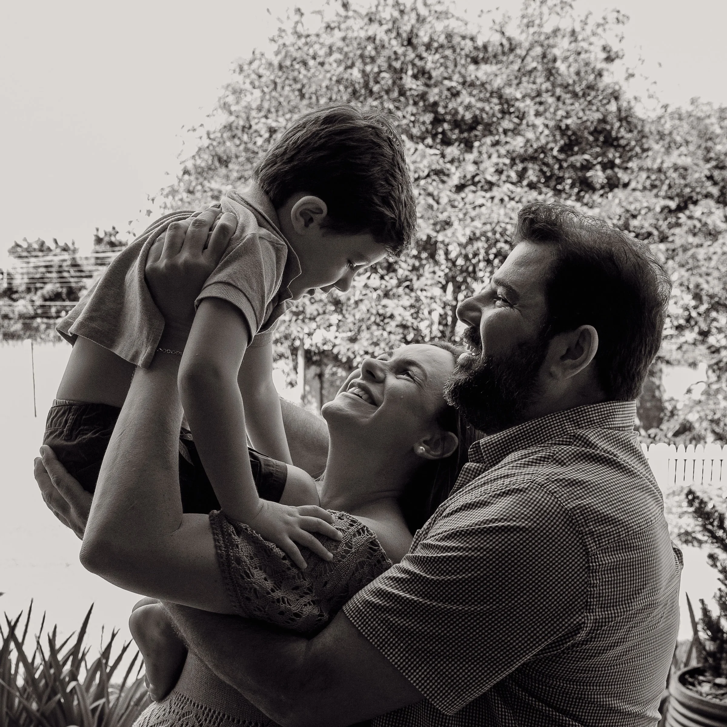 Black and white portrait of parents holding their baby close