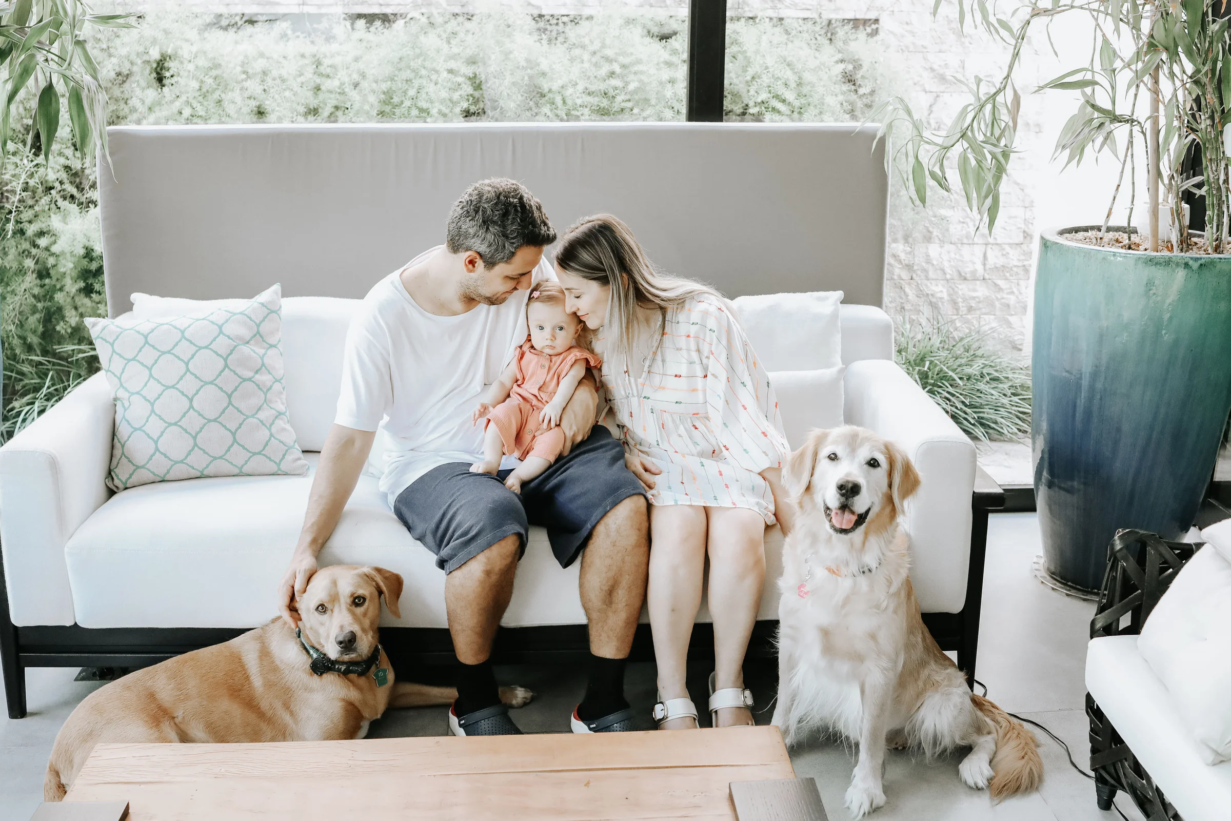Family sitting on the couch at home with their two dogs