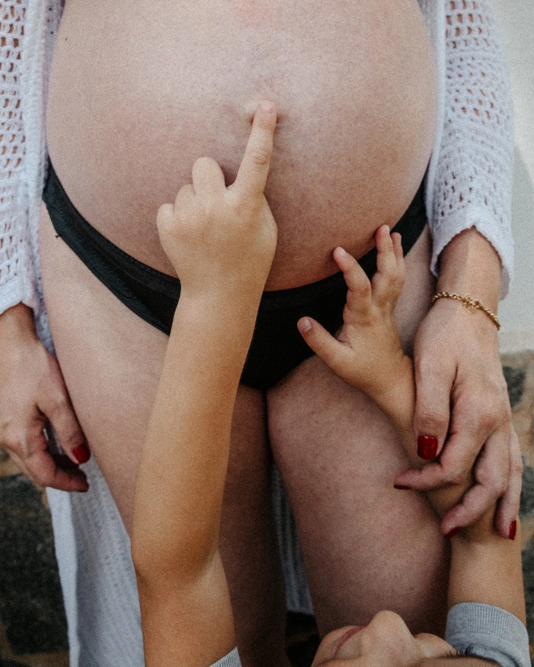 Expecting mother and partner with hands resting on her belly