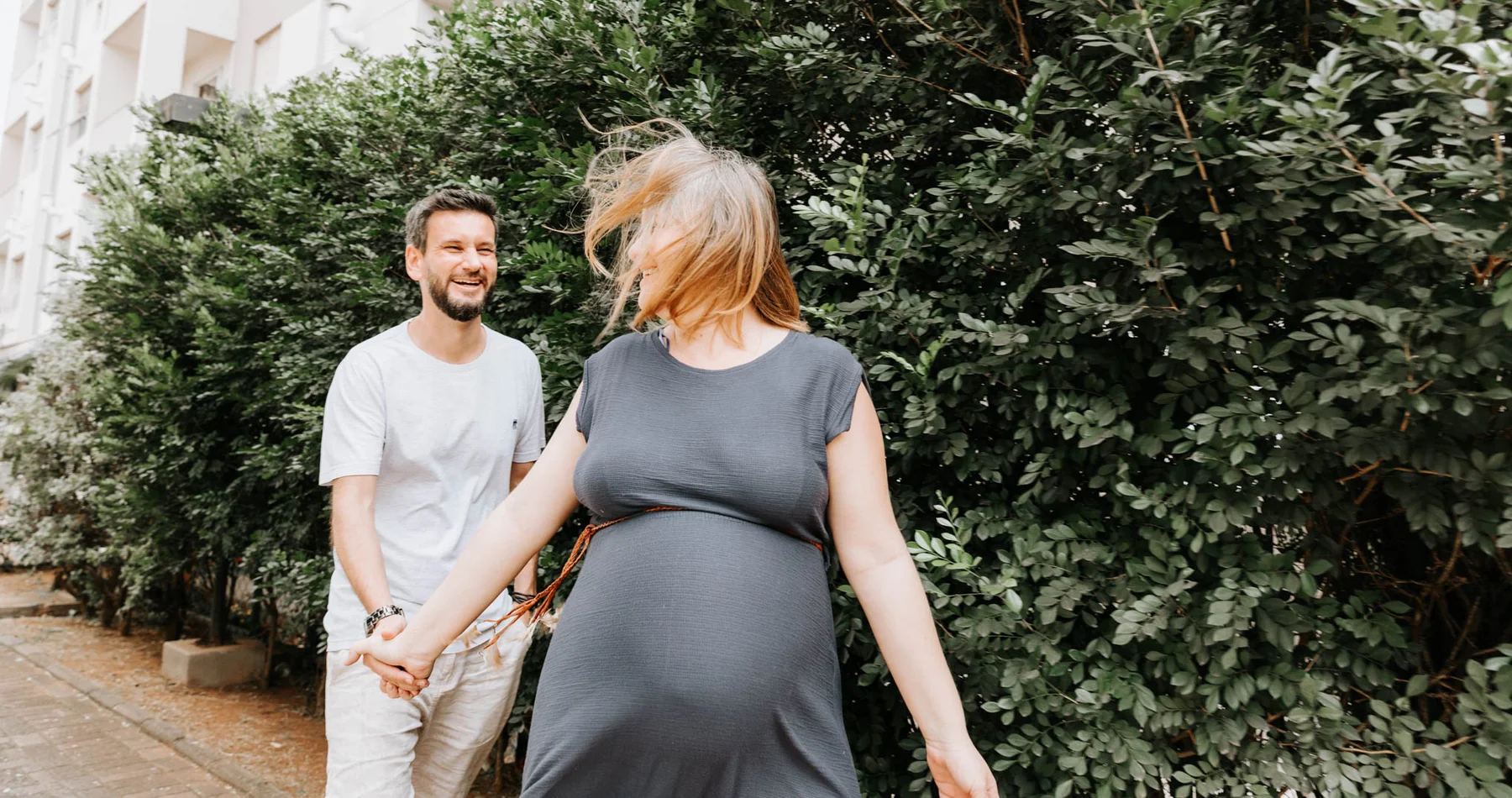Expecting parents walking hand in hand outdoors