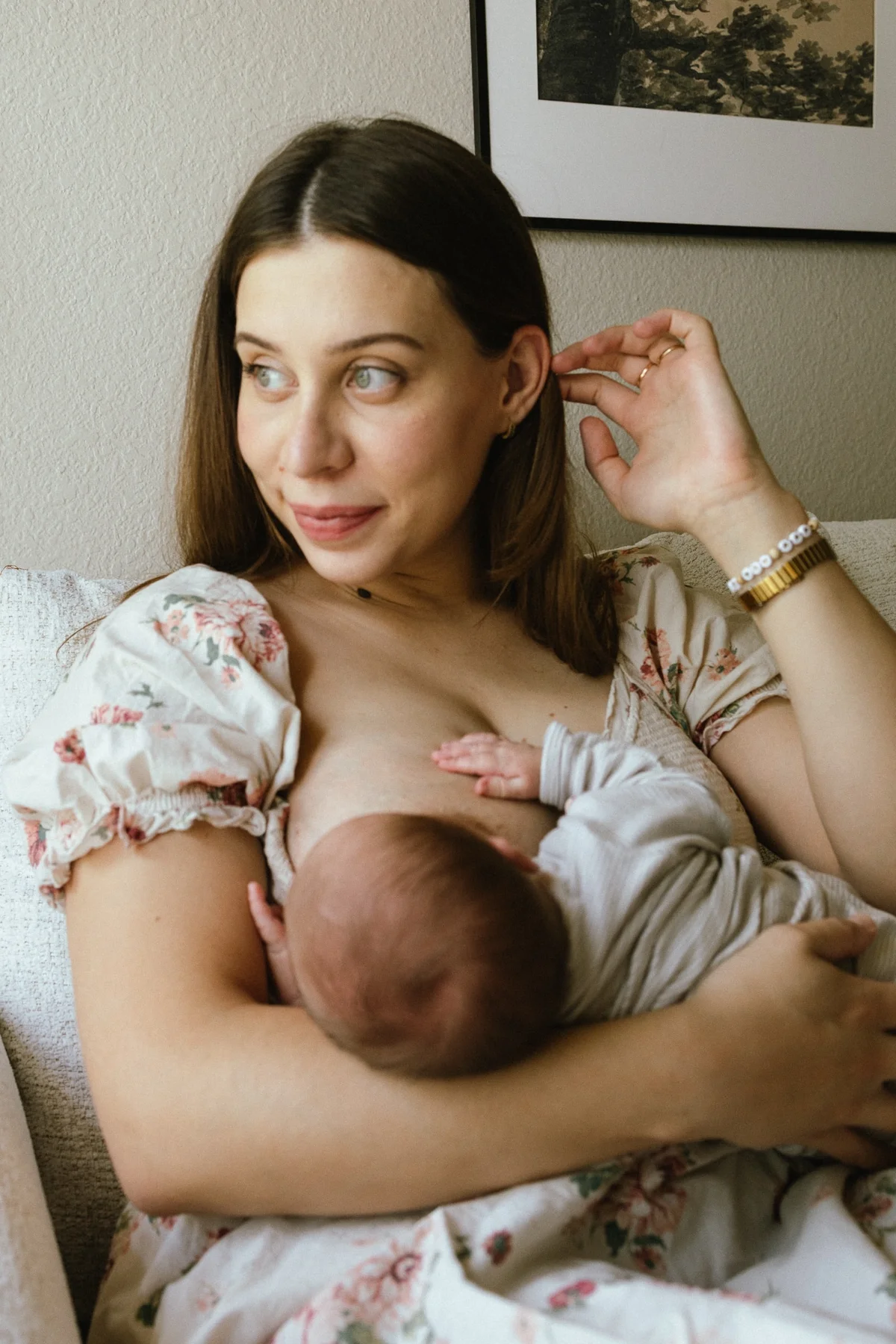 Mother nursing her newborn on the sofa at home, in home newborn session
